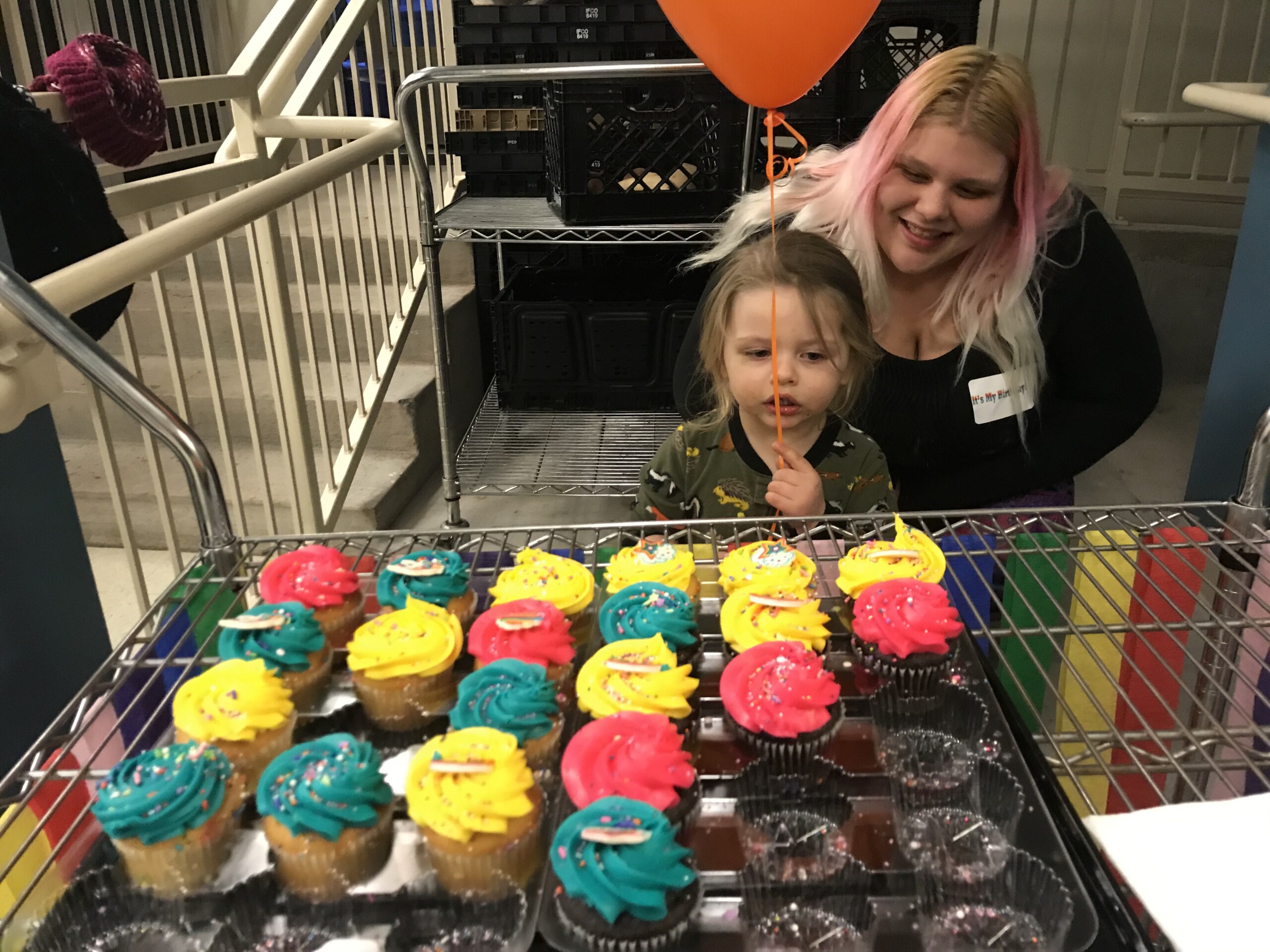 Child and Mother looking at some cupcakes
