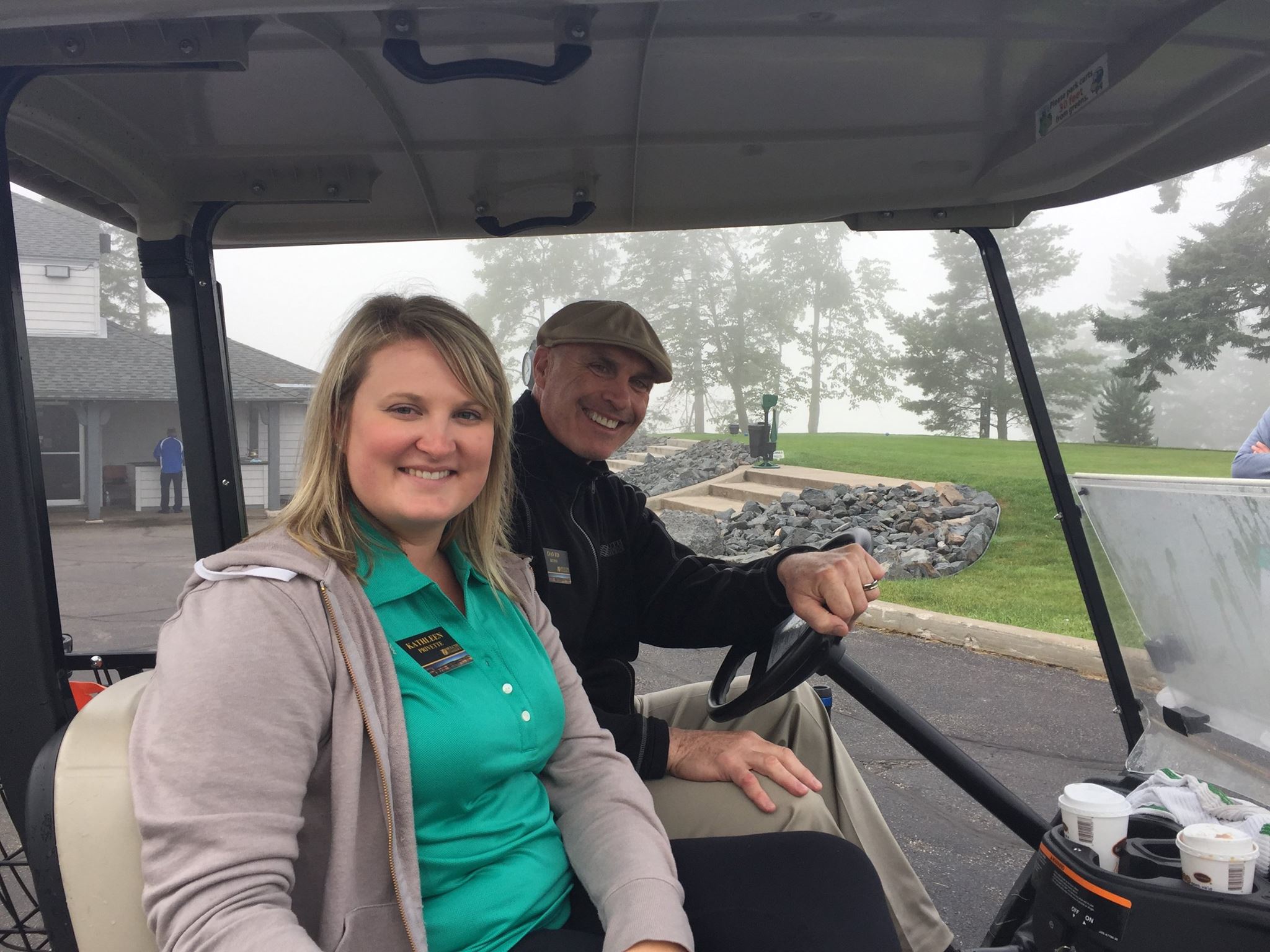 Smiling man and woman on golf cart