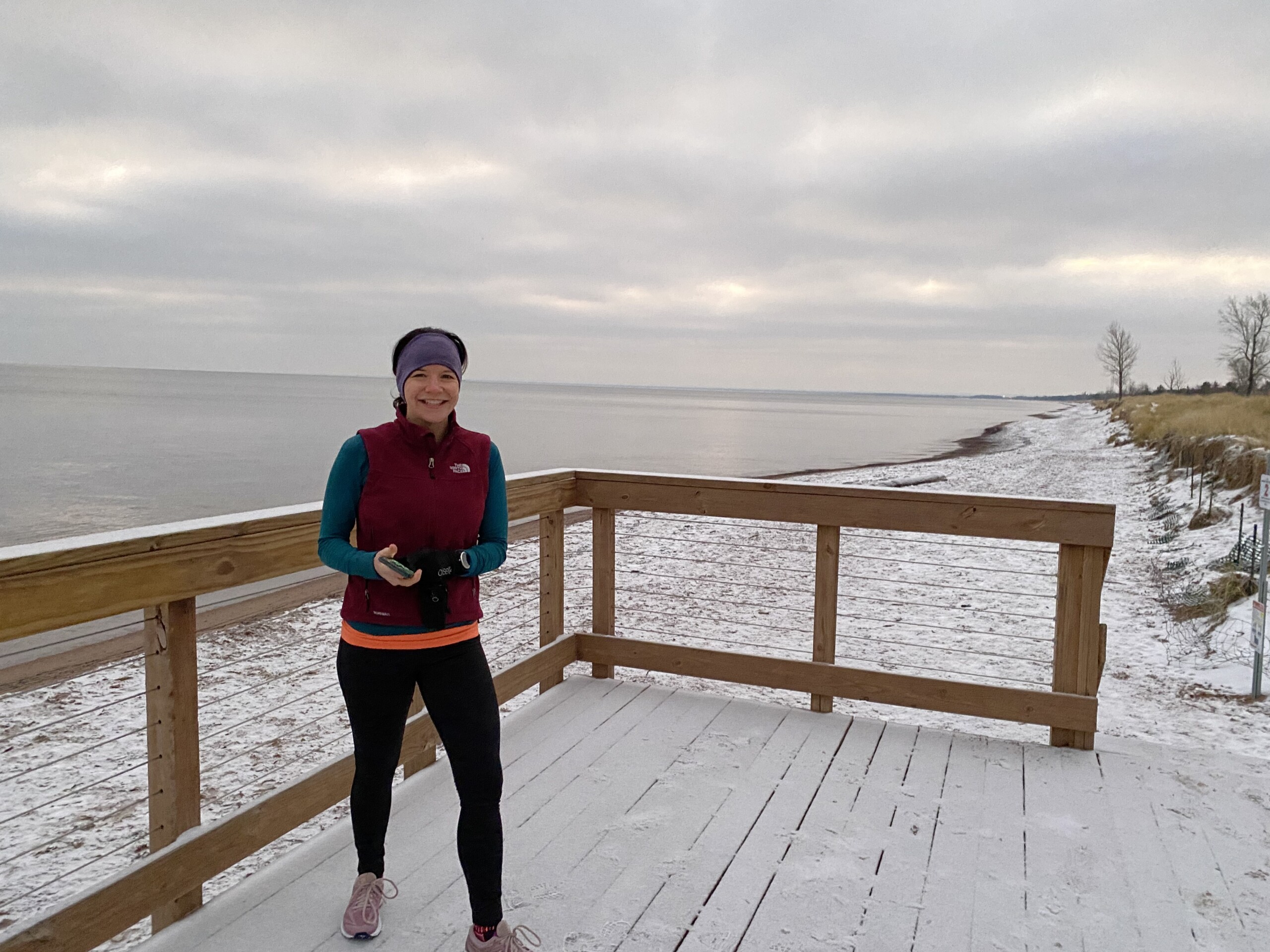 woman running outside in the cold by lake superior