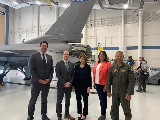 People standing in front of a fighter jet