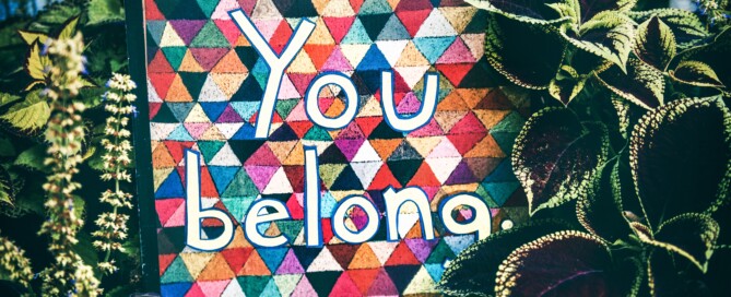 You belong sign surrounded by plants